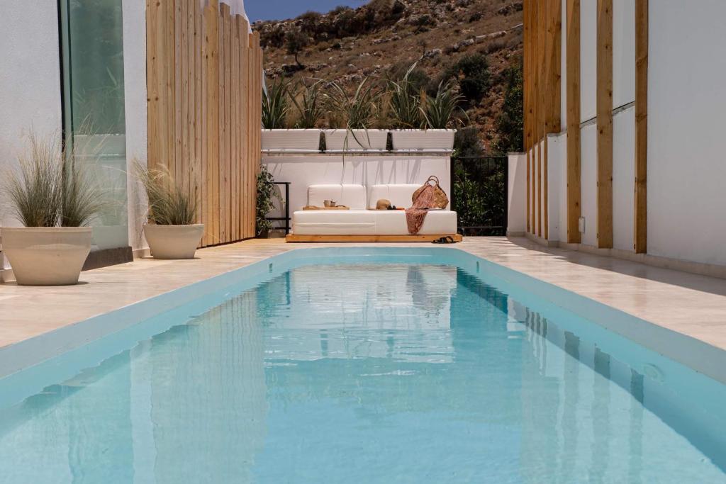 una piscina en una casa con sofá y un sofá cama en Casa Prasoul Villa with Heated Pool & Fitness area, en Prasiaí