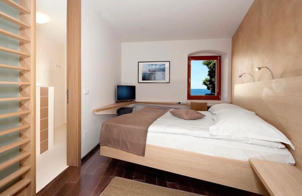 sypialnia z dużym łóżkiem i lustrem w obiekcie Boutique Wrungel w mieście Vrsar