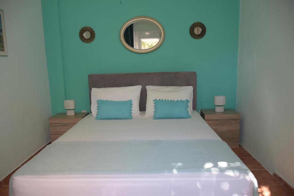 1 dormitorio con 1 cama grande y pared azul en Katerina's Apartment, en Toroni