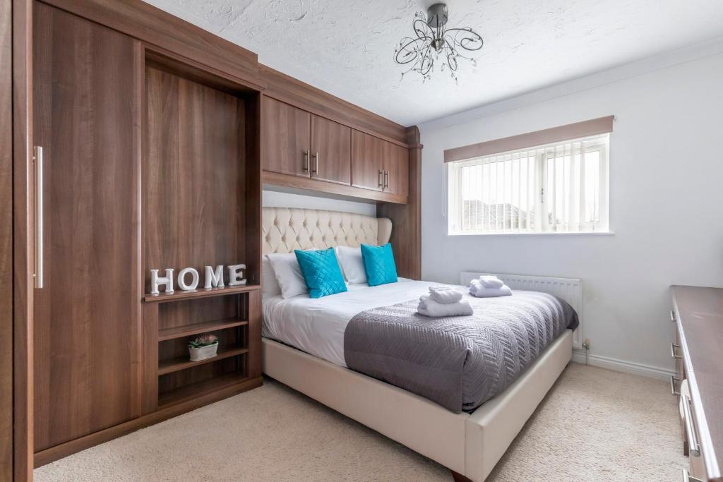 um quarto com uma cama com almofadas azuis em One Harp Hill em Cheltenham