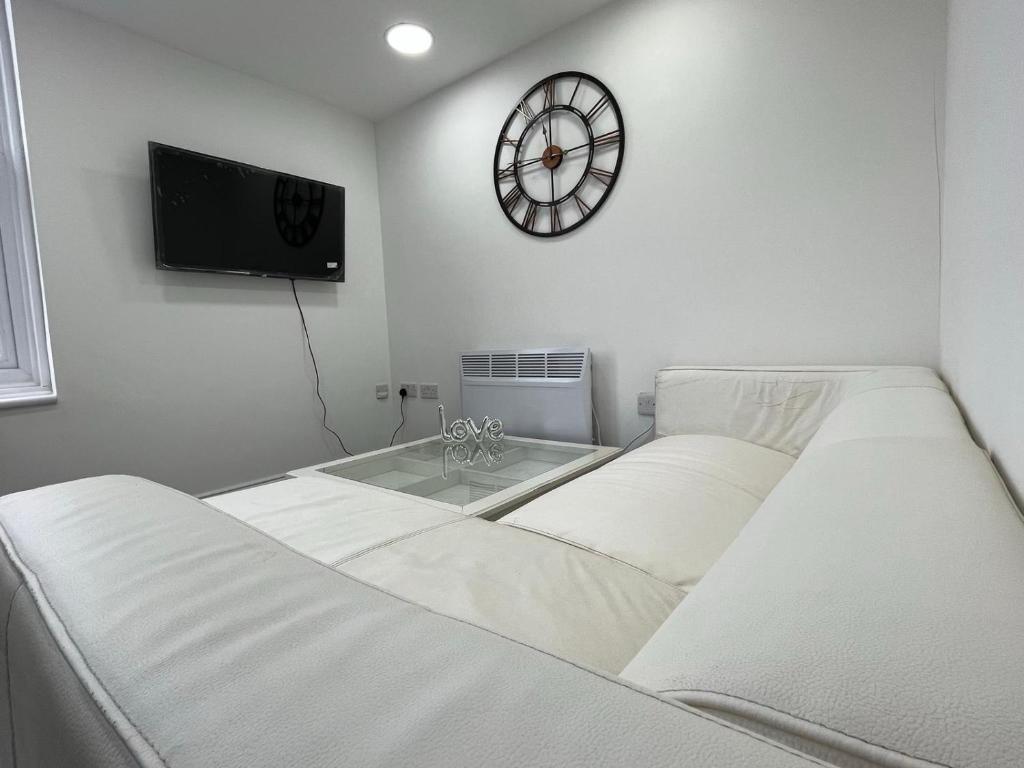 um quarto com duas camas e um relógio na parede em Apartment in St Denys em Southampton