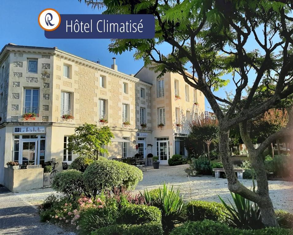 a hotel in the middle of a courtyard with a building at Hotel Le Richelieu - Royan Atlantique in Saujon