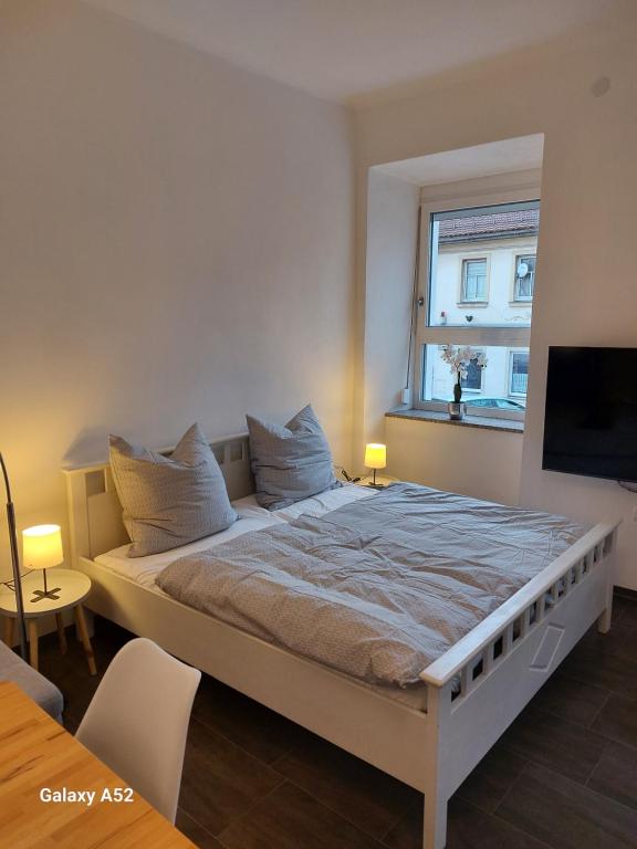 a large bed in a room with a window at Apartments im Mardefeldpalais in Ansbach