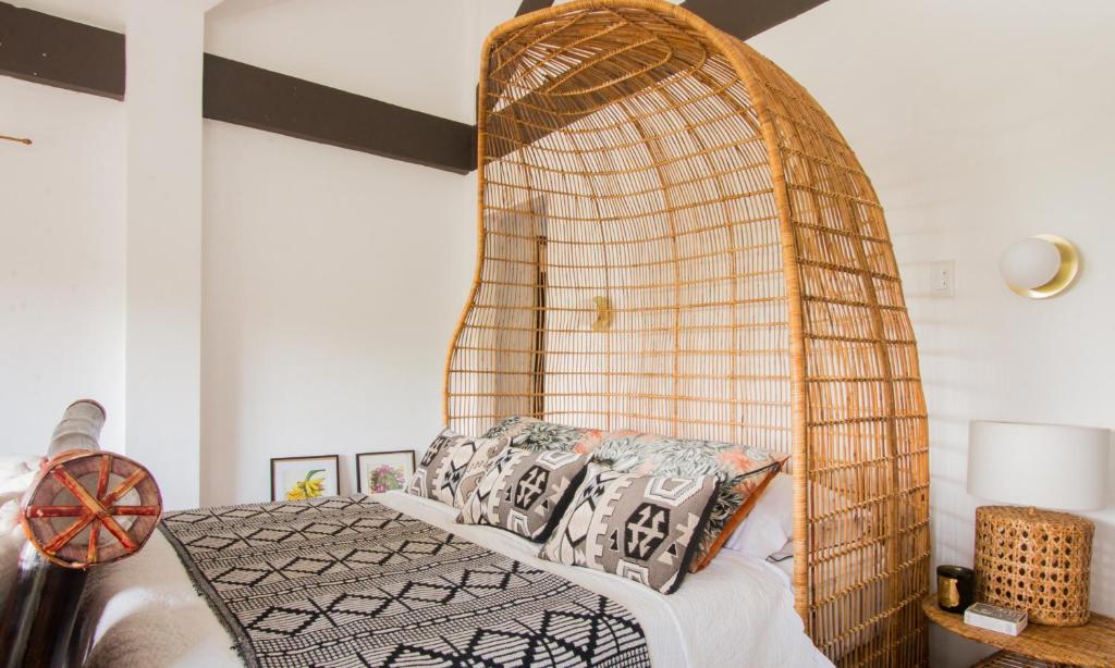 a bedroom with a bed with a bamboo headboard at Villa Kulintang in Donsol