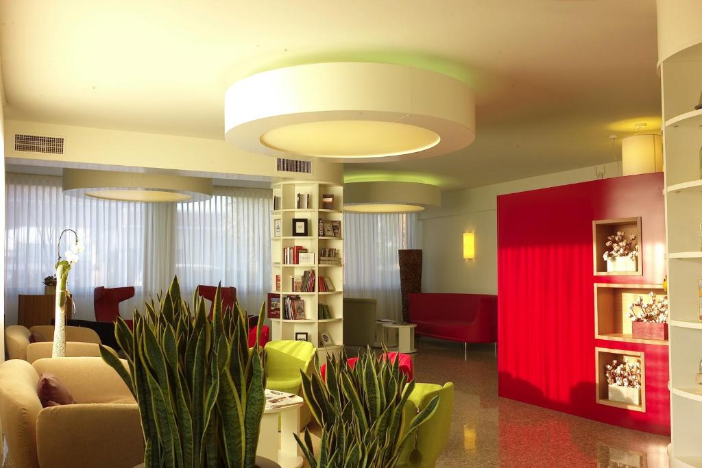 een woonkamer met een bank en een rode muur bij Hotel Eurorest in Conegliano