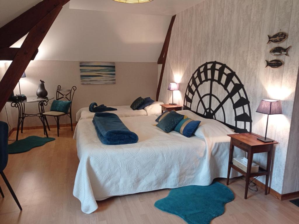 a bedroom with two beds with blue pillows on them at Chambres d'Hôtes Au Moulin 