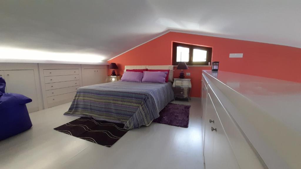 - une chambre avec des murs rouges et un lit avec des oreillers violets dans l'établissement Il Sogno Loft Indipendente, à Crotone