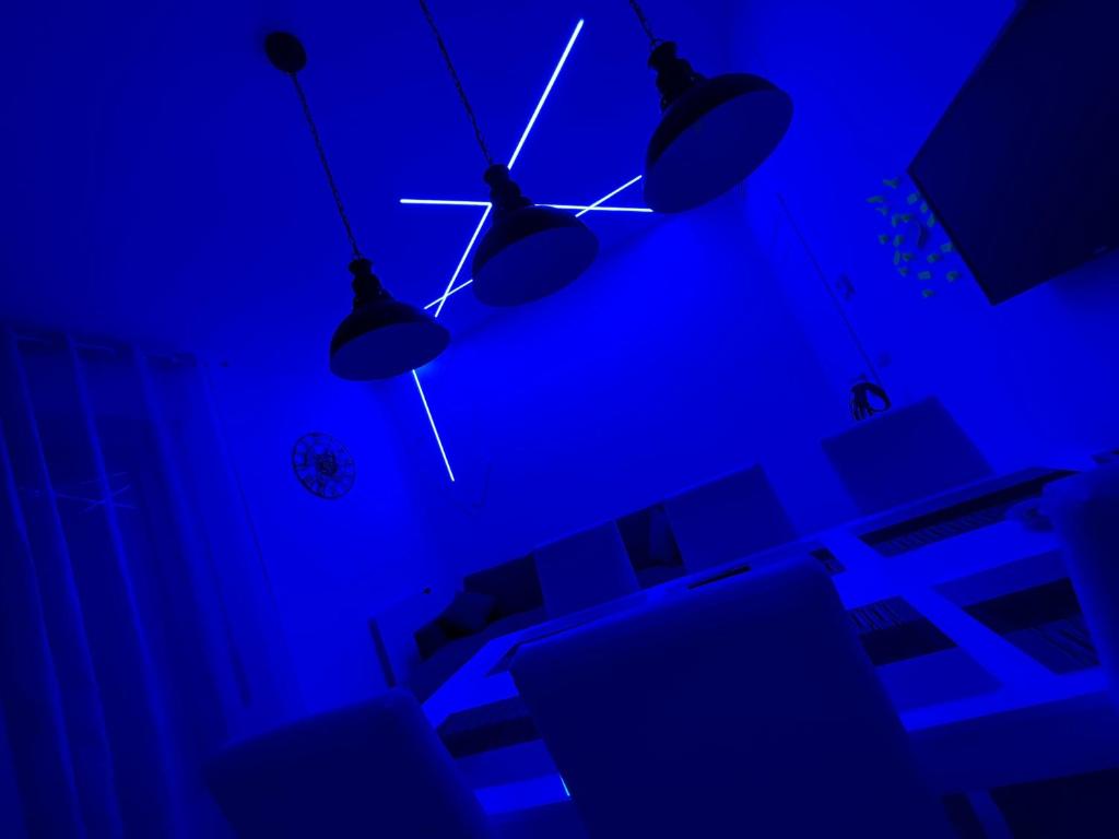 Habitación azul con tres luces colgando del techo en Appartamento Meta di Sorrento Le Sirene, en Meta