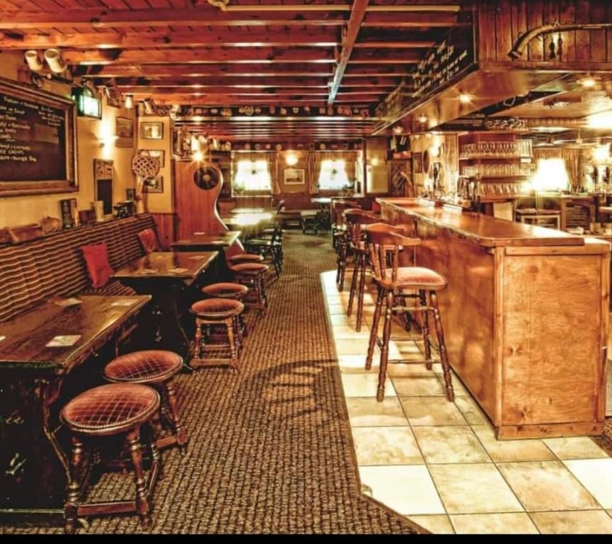 um bar com bancos e mesas num restaurante em The Old Royal George em Northallerton