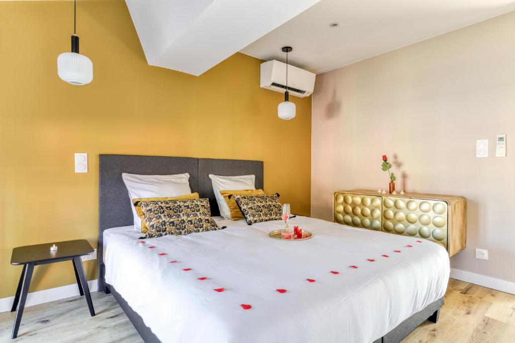 Un dormitorio con una cama grande con un arco rojo. en Les Clés de Laure - Le 11 JACUZZI avec Terrasses Clim Netflix Parking, en Carcassonne