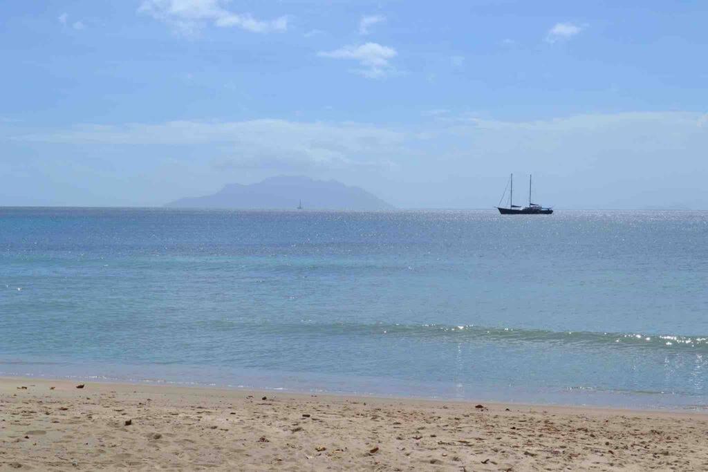 - une plage avec un bateau dans l'eau dans l'établissement Riva D Etruschi Seychelles, à Bel Ombre