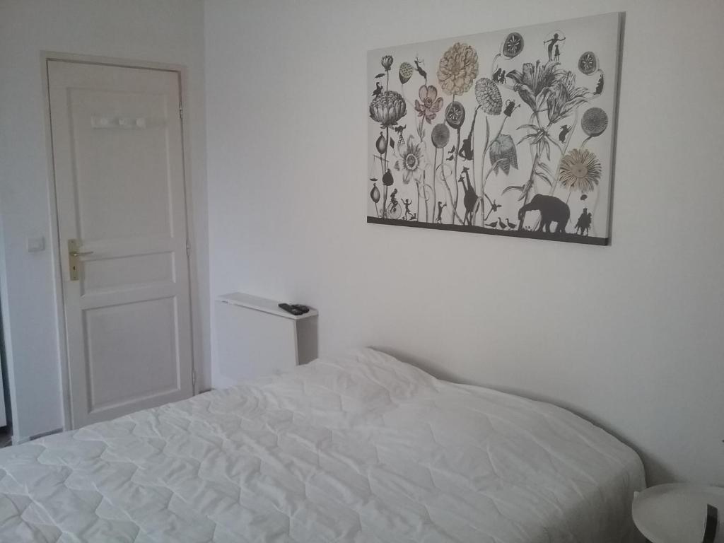 a bedroom with a bed and a picture on the wall at UNE CHAMBRE EN VILLE in L'Isle-sur-la-Sorgue