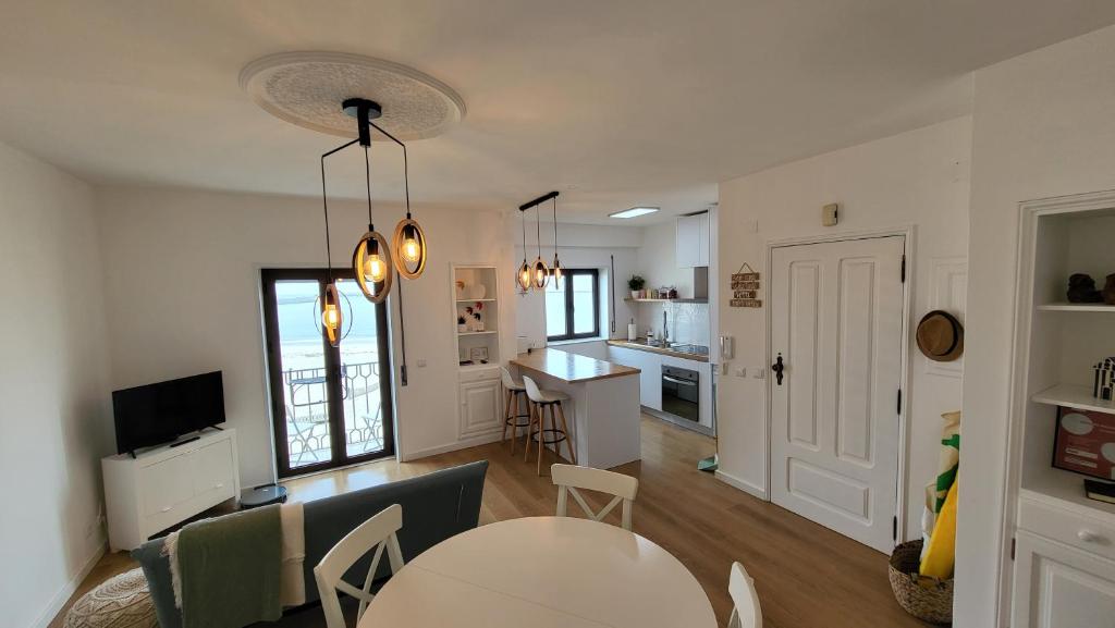 a living room with a table and a kitchen at SonhosQrodopiam Praia da Barra in Praia da Barra