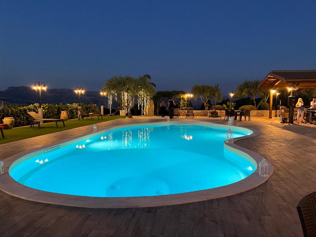 a large blue swimming pool at night at Agriturismo Tenuta San Giovanni Casale Leto in SantʼAngelo Muxaro