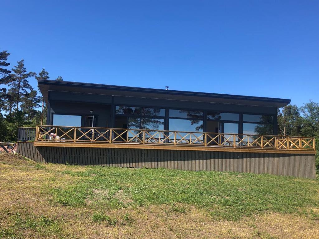 a house with a black roof and a balcony at Kemping in Föglö