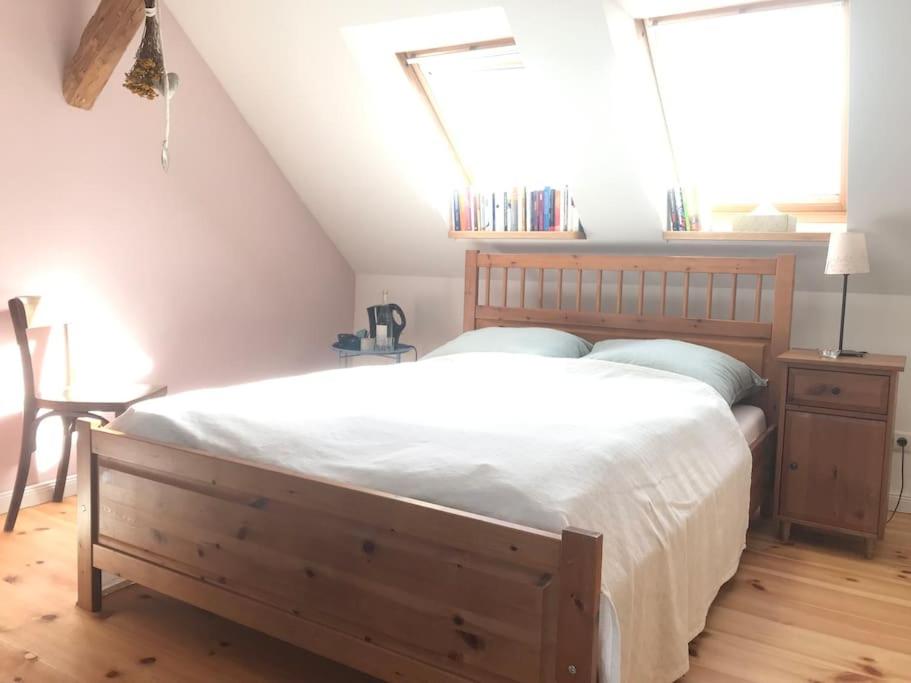 Schlafzimmer mit einem großen Bett mit einem Kopfteil aus Holz in der Unterkunft Dachgeschosszimmer mit Terrasse in Wismar