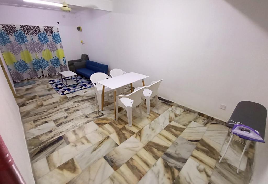 Habitación con mesa, sillas y suelo de madera. en Simple Beseri Homestay, en Kangar