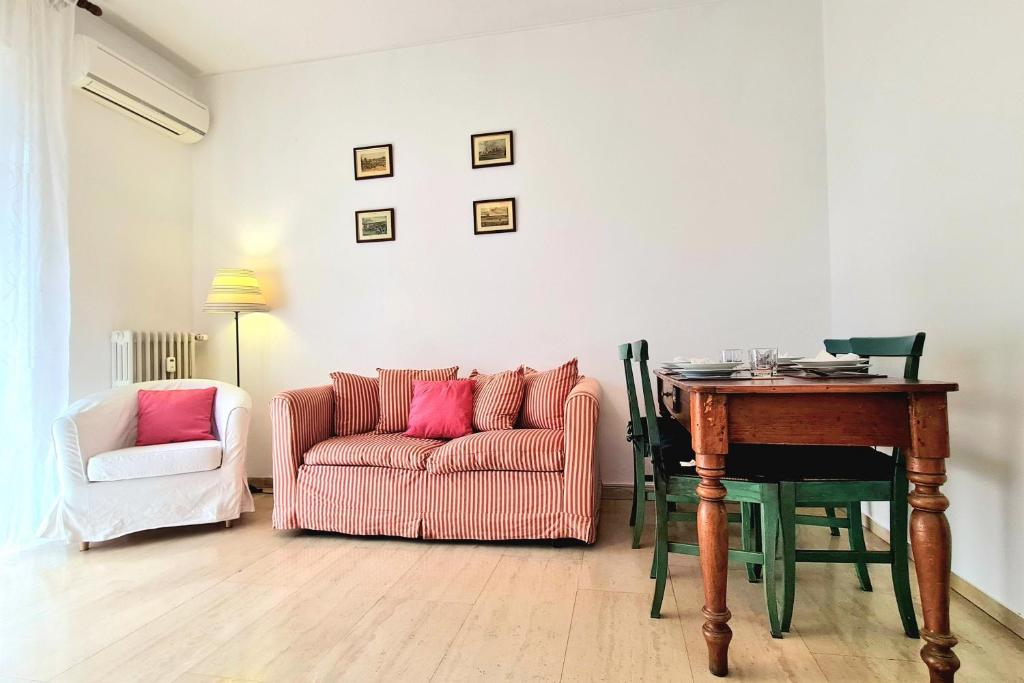 een woonkamer met een roze bank en een tafel bij Milano San Siro Stadio appartamento in Milaan