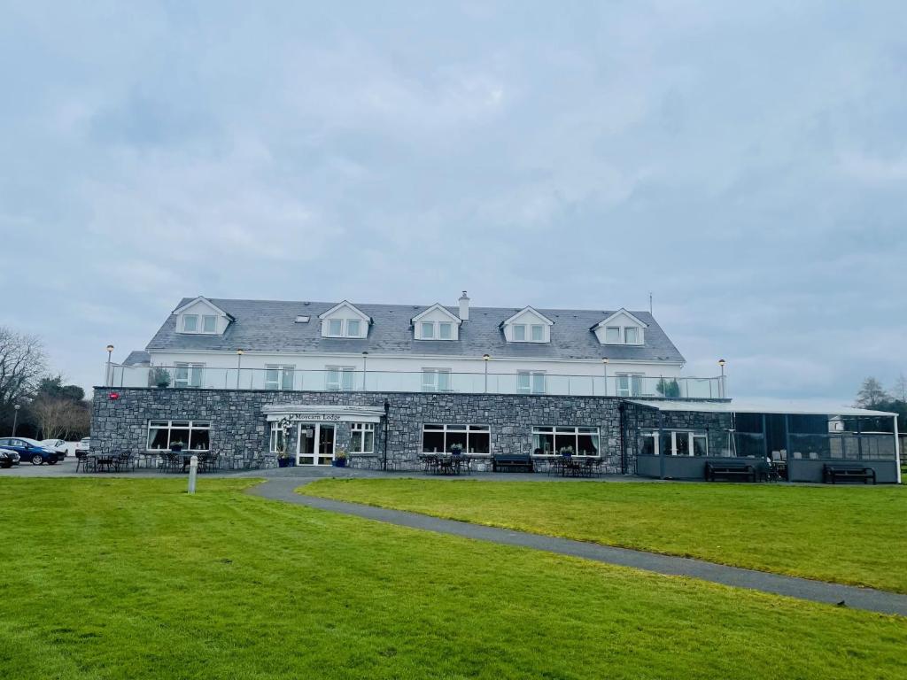 a large stone building with a grass field in front at Moycarn Lodge & Marina in Ballinasloe