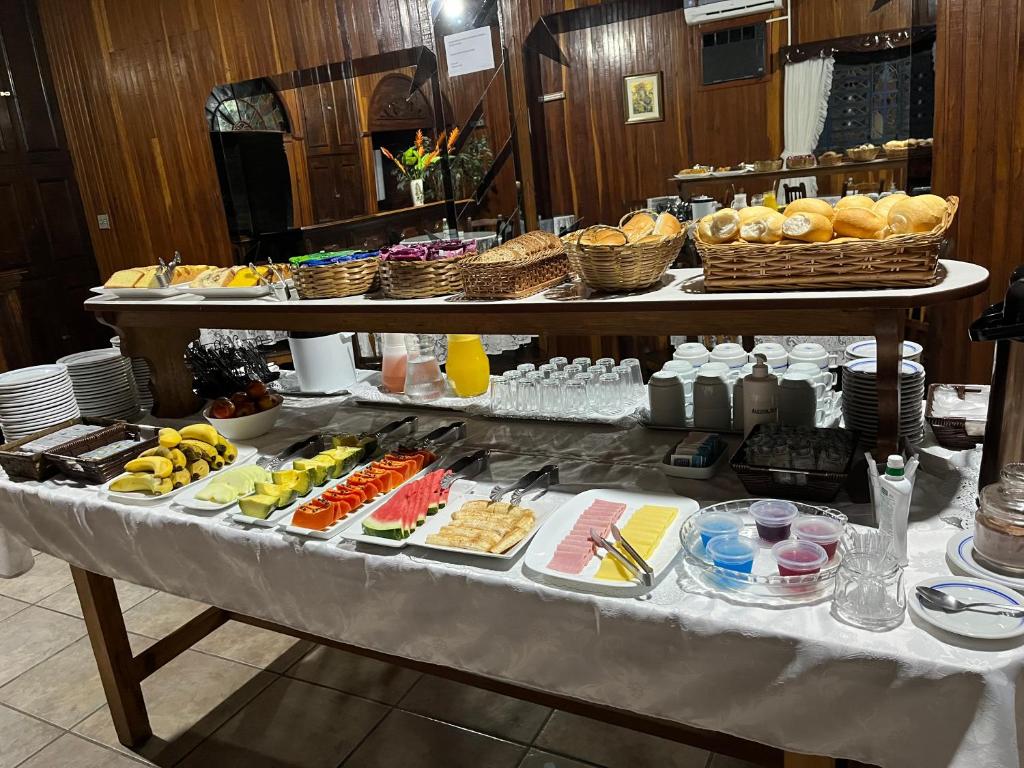 uma mesa de buffet com muitos tipos diferentes de alimentos em Hotel Vila Rica em Maringá