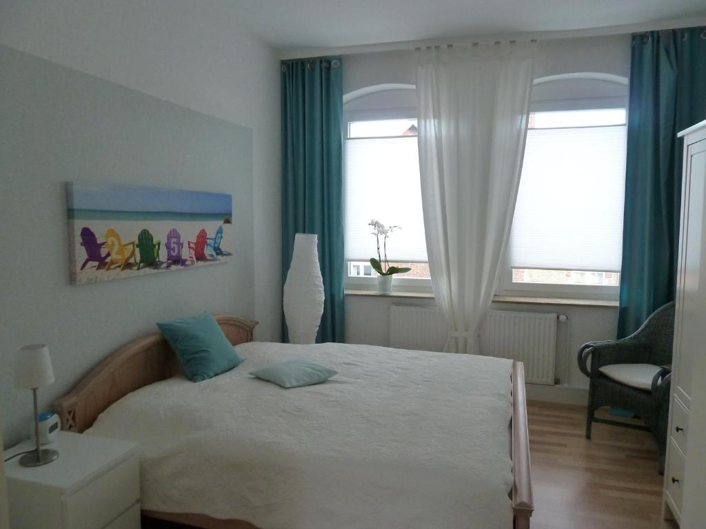 a bedroom with a bed and two windows at Glück im Kohlenpott in Bottrop
