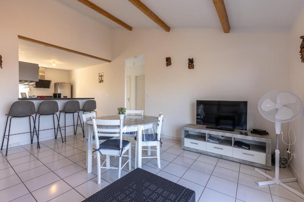 a living room with a table and a tv at LaConciergerieJonzac, Appartement La Désirade in Jonzac