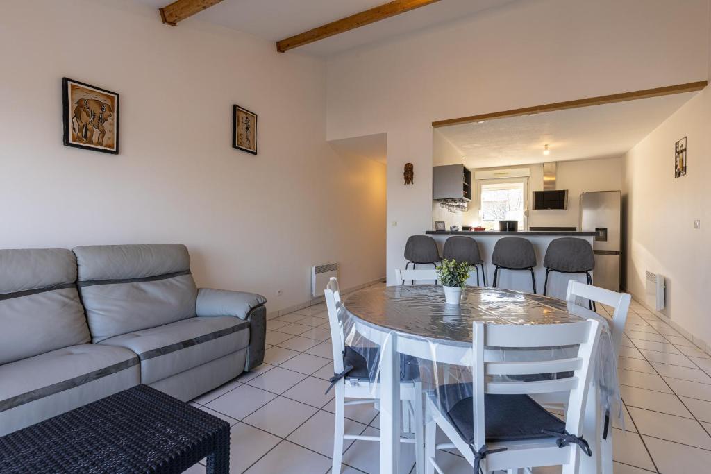 a living room with a table and a couch at LaConciergerieJonzac, Appartement La Désirade in Jonzac