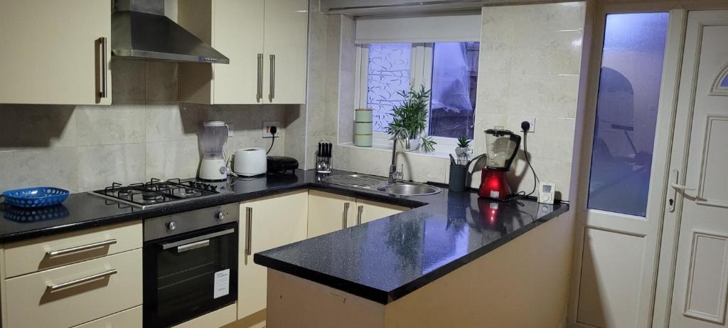 a kitchen with a sink and a counter top at Entire 2 Bedroom House - Manchester in Manchester