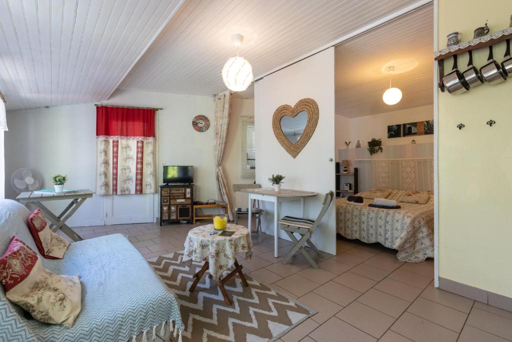 een woonkamer met een bank en een tafel bij Maisonnette La Chaleureuse in Jonzac