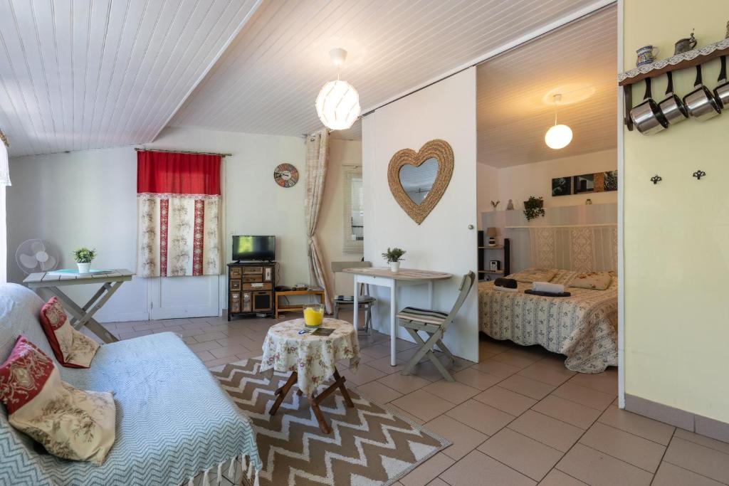 a living room with a couch and a table at Maisonnette La Chaleureuse in Jonzac