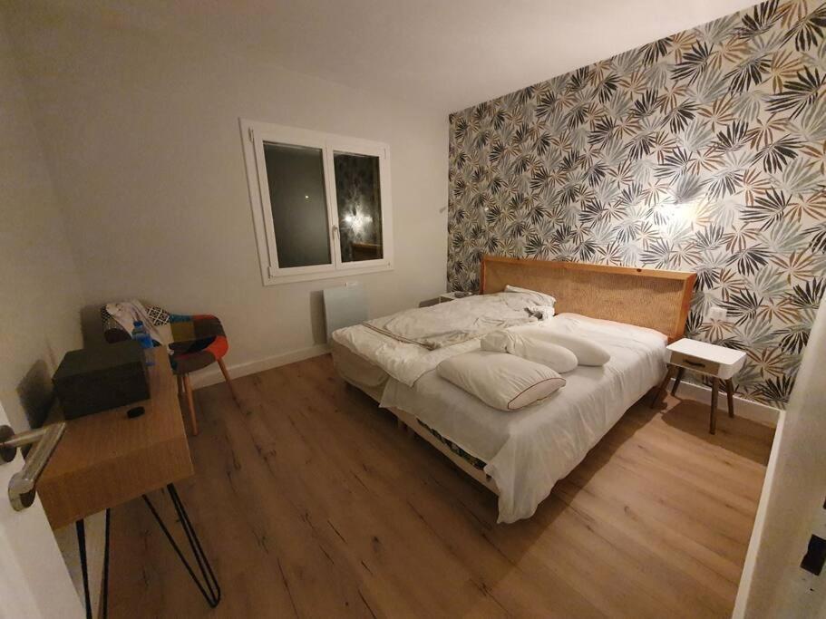 um quarto com uma cama e piso em madeira em L'Abri Côtier, villa avec piscine au coeur des vignes em Caux