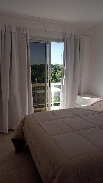a bedroom with a bed and a large window at TERAPIA DIVINA in Saladillo