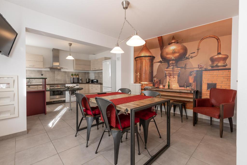 cocina y comedor con mesa y sillas en LaConciergerieJonzac, Maison de ville ALAMBIC, en Jonzac