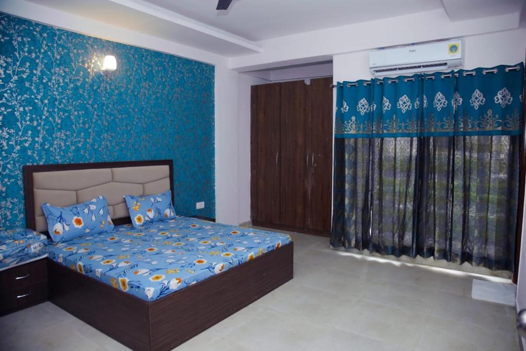 1 dormitorio con cama y pared azul en 2 BHK Independent Flat at Ganpati Infinity Vrinadvan en Mathura