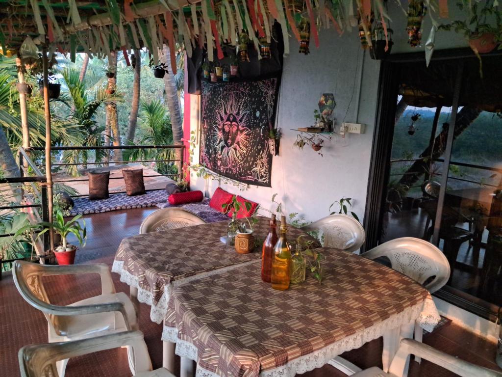 a dining room with a table and chairs with bottles on it at Bageecha B&B- Vaayu in Alibaug