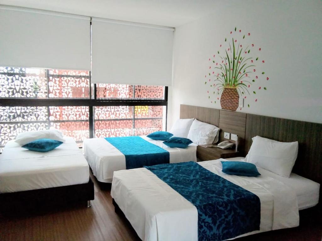 Habitación de hotel con 2 camas y ventana en Suite Sumapaz Hotel en Melgar