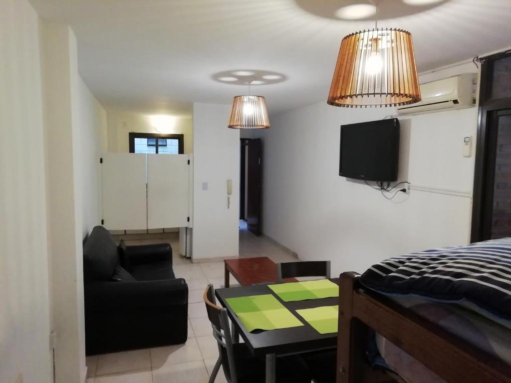 een kamer met een bed, een tafel en een bank bij Balcarce Suits PB in Bell Ville