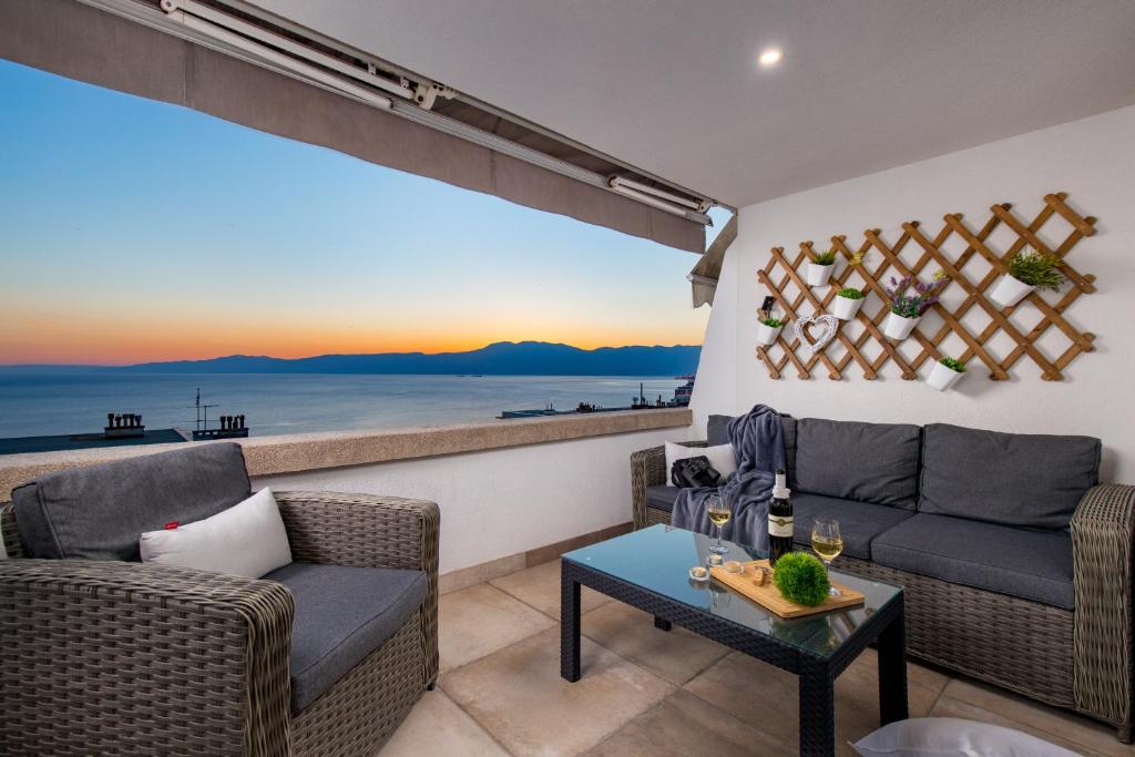 Lux Apartment SKY VIEW في رييكا: غرفة معيشة مع كنب وإطلالة على المحيط