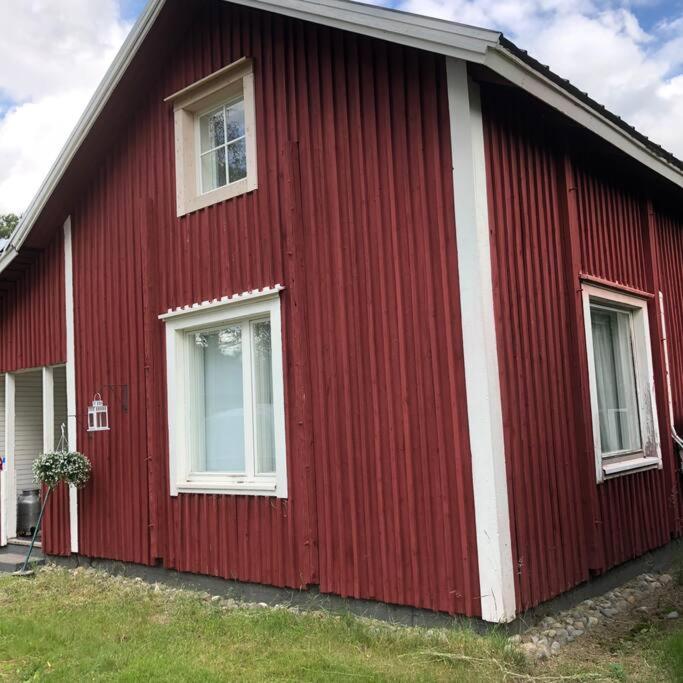 a red house with two windows on the side of it at Villa Oiva in Ylihärmä