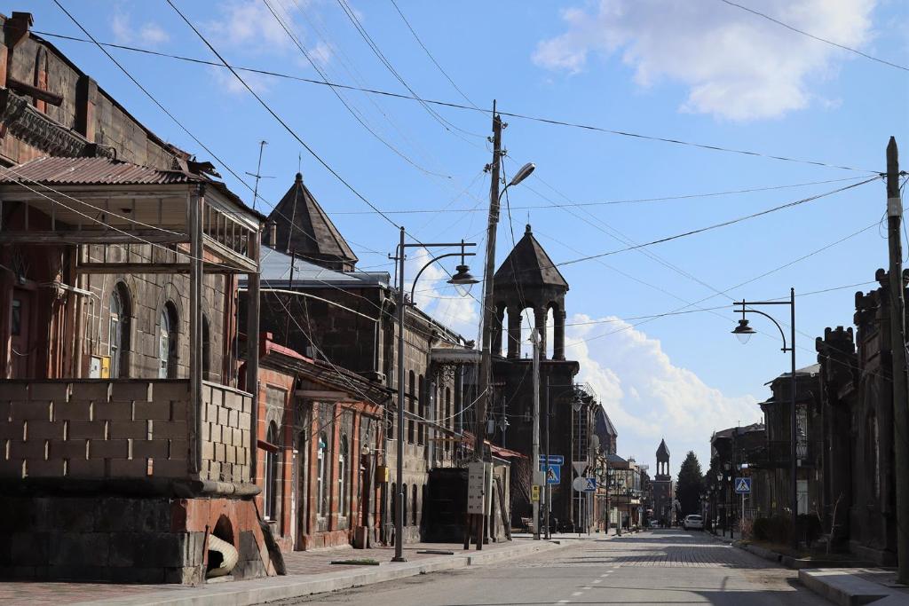 una calle vacía en un viejo pueblo con una iglesia en Hakobyan's Home, en Gyumri