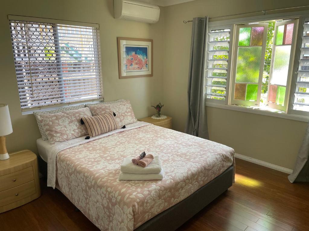 a bedroom with a bed with a pair of shoes on it at Cheerful city house in Cairns