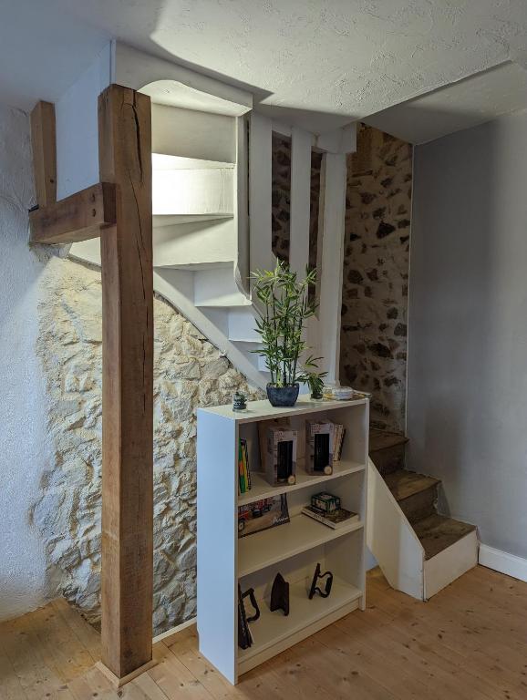 a room with a staircase and a shelf with shoes at Maison de quartier populaire. in Aubusson