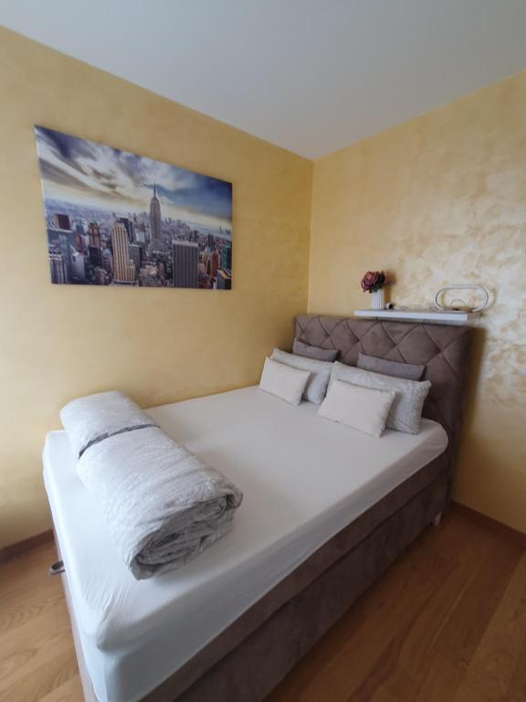 een slaapkamer met een groot bed met witte lakens bij Centar view lux in Novi Sad