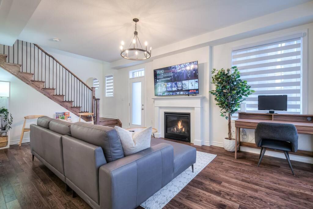 a living room with a couch and a fireplace at Modern Comforts and Spacious Living 4B/3.5 Bath in Pickering