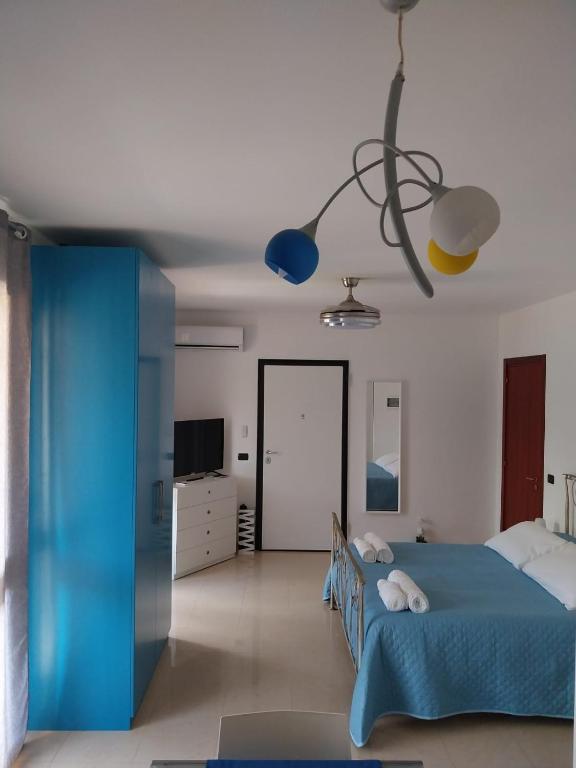 una camera con letto blu e TV di Appartamento Memorie a Otranto