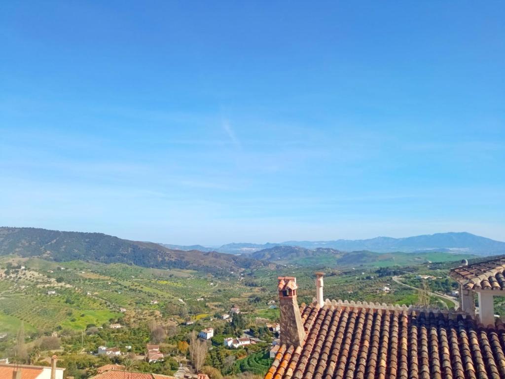 vistas al techo de una casa con montañas en el fondo en La Jacaranda en Casarabonela