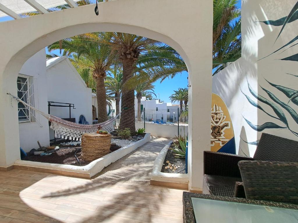 un patio al aire libre con palmeras y una hamaca en Palm Point, en Costa Calma