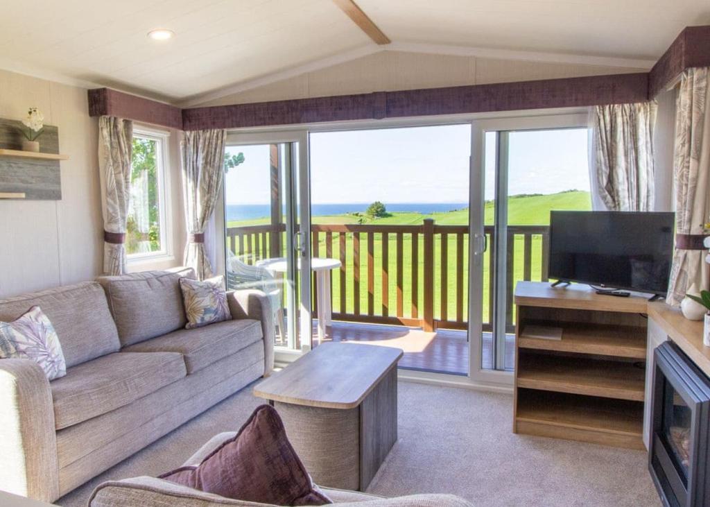 a living room with a couch and a television at Heads Of Ayr Holiday Park in Ayr