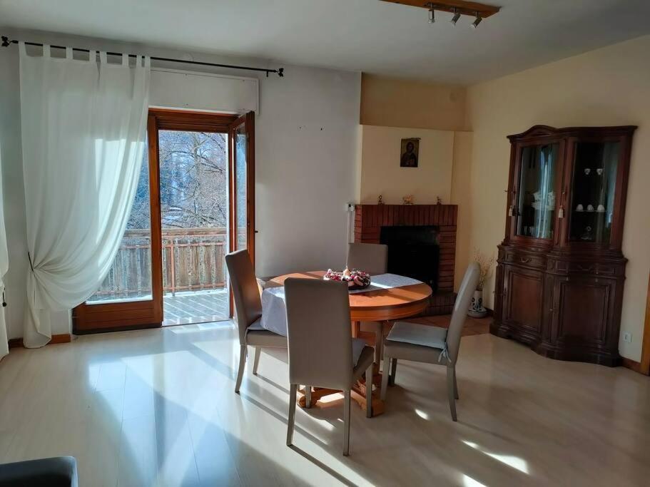 Il Terrazzo Sulle Dolomiti في Cibiana: غرفة طعام مع طاولة وكراسي خشبية