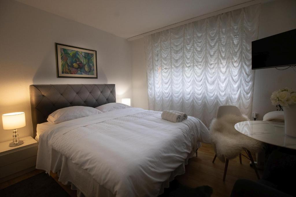 - une chambre avec un lit blanc et une fenêtre dans l'établissement Apartman BARBARA, à Vinkovci